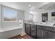 Bright bathroom with double sink vanity, soaking tub, and modern fixtures at 3641 Portici Ln, Henderson, NV 89044