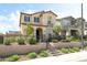 Charming two-story home with a landscaped front yard, black fence, and stairs leading to an arched doorway at 3641 Portici Ln, Henderson, NV 89044