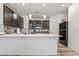Modern kitchen with dark wood cabinets, white countertops, stainless steel appliances, and wood flooring at 3641 Portici Ln, Henderson, NV 89044