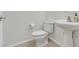 Half-bathroom with a modern pedestal sink and a standard toilet set against a white wall with tile floors at 3689 Bufflehead St, Las Vegas, NV 89122