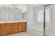 Bathroom featuring double sinks, wood cabinets, a large mirror, a soaking tub, and a glass-enclosed shower at 3689 Bufflehead St, Las Vegas, NV 89122