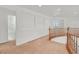 Upstairs hallway with neutral walls, carpet flooring, and a wooden railing overlooking the floor below at 3689 Bufflehead St, Las Vegas, NV 89122