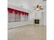 Bright living room showcasing a fireplace, neutral walls, tile floors, and large windows with red curtains at 3689 Bufflehead St, Las Vegas, NV 89122