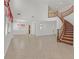Open-concept living room with tiled floors and stairs with wood railing at 3689 Bufflehead St, Las Vegas, NV 89122
