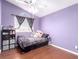 Bedroom in lavender features a ceiling fan, window, and dark wood floors at 3825 Manhattan Bridge Pl, North Las Vegas, NV 89032