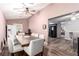 An airy dining room with gray cushioned chairs, a wood table, and connection to another dining room at 3825 Manhattan Bridge Pl, North Las Vegas, NV 89032