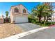 Two-story home featuring a well-maintained front yard with a mature palm tree and desert landscaping at 3825 Manhattan Bridge Pl, North Las Vegas, NV 89032