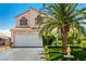 Charming two-story home featuring a well-maintained front yard and a mature palm tree at 3825 Manhattan Bridge Pl, North Las Vegas, NV 89032