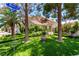 Beautifully landscaped front yard with mature trees and lush green lawn, complemented by charming street signage at 3825 Manhattan Bridge Pl, North Las Vegas, NV 89032