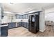 Modern kitchen with gray cabinets, stainless steel appliances, and a doorway to the living room at 3825 Manhattan Bridge Pl, North Las Vegas, NV 89032