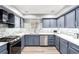 Modern kitchen featuring stainless steel appliances, and blue and gray backsplash with quartz countertops at 3825 Manhattan Bridge Pl, North Las Vegas, NV 89032