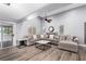 Large living room with laminate floors, featuring a comfortable gray couch and access to the backyard pool at 3825 Manhattan Bridge Pl, North Las Vegas, NV 89032