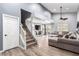 Spacious living room with vaulted ceiling, laminate floors, and a staircase to second floor at 3825 Manhattan Bridge Pl, North Las Vegas, NV 89032