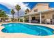 Inviting pool area with covered patio and lush landscaping in backyard at 3825 Manhattan Bridge Pl, North Las Vegas, NV 89032