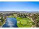 Aerial view of Rhodes Ranch community featuring a golf course, lake and residences with mountain views at 389 Fringe Ruff Dr, Las Vegas, NV 89148