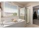 Bright bathroom featuring a large tub, glass shower, and a window view at 389 Fringe Ruff Dr, Las Vegas, NV 89148