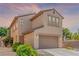 Two-story home features a neutral-colored exterior, attached garage, and desert landscaping at 389 Fringe Ruff Dr, Las Vegas, NV 89148