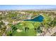 A scenic aerial view of a golf course featuring a tranquil lake, lush green fairways, and mature palm trees at 389 Fringe Ruff Dr, Las Vegas, NV 89148
