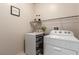 A laundry room with a washer, dryer, and overhead shelving for storage at 389 Fringe Ruff Dr, Las Vegas, NV 89148