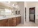 Spacious main bathroom with dual sinks, wood cabinets, and walk-in closet at 389 Fringe Ruff Dr, Las Vegas, NV 89148