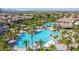 Aerial view of a large community pool surrounded by palm trees, umbrellas, and lounge chairs, promising relaxation and recreation at 389 Fringe Ruff Dr, Las Vegas, NV 89148