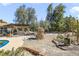 Spacious backyard featuring desert landscaping, a unique stone structure, and a charming pergola-covered seating area at 4343 Sharpshooter Ln, North Las Vegas, NV 89031