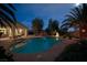 Inviting backyard pool area, perfect for relaxing and entertaining, enhanced by palm trees and ambient lighting at 4343 Sharpshooter Ln, North Las Vegas, NV 89031