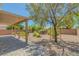 Backyard featuring a covered patio and a landscaped area with mature trees at 4369 Meadowlark Wing Way, North Las Vegas, NV 89084