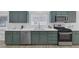 Updated kitchen features green cabinets, stainless steel appliances, and white quartz countertops at 4369 Meadowlark Wing Way, North Las Vegas, NV 89084