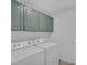 Laundry room with stacked washer and dryer, green cabinets, and white walls at 4369 Meadowlark Wing Way, North Las Vegas, NV 89084