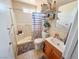 Well-lit bathroom featuring a shower-tub combo, neutral tile, and ample shelving for storage at 4428 Los Reyes Ct, Las Vegas, NV 89121