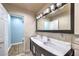 Bathroom featuring double sinks, vanity with storage, modern lighting, and a large mirror at 4428 Los Reyes Ct, Las Vegas, NV 89121
