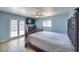 Cozy bedroom with wood-look floors, ceiling fan, and double doors to the backyard at 4428 Los Reyes Ct, Las Vegas, NV 89121