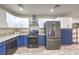 Modern kitchen featuring stainless steel appliances, granite countertops, and blue and white cabinets at 4428 Los Reyes Ct, Las Vegas, NV 89121