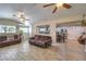 Open-concept living room with ceiling fans, wood-look tile floors, and comfortable brown sofas at 4428 Los Reyes Ct, Las Vegas, NV 89121