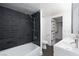 Modern bathroom features a tub, gray tiling, and dual sinks at 4778 Knotty Pine Way, Las Vegas, NV 89124