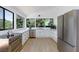 Modern kitchen featuring stainless steel appliances, white cabinetry, and expansive windows with tree views at 4778 Knotty Pine Way, Las Vegas, NV 89124