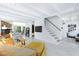Bright living room with white beamed ceilings, stone fireplace, and a staircase leading to the upper level at 4778 Knotty Pine Way, Las Vegas, NV 89124