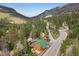 Aerial view of a cabin with a green roof amidst a mountain forest and winding roads at 4830 Silver Tip Way, Mount Charleston, NV 89124