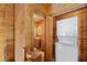 Wood-paneled bathroom with a double vanity, framed mirror and stacked washer/dryer unit at 4830 Silver Tip Way, Mount Charleston, NV 89124