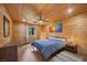 Bedroom with knotty wood walls, hardwood floors, queen bed, and accent art at 4830 Silver Tip Way, Mount Charleston, NV 89124