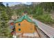 Exterior of a mountain cabin with wood siding, green roof, and fenced patio, surrounded by trees and a scenic road at 4830 Silver Tip Way, Mount Charleston, NV 89124