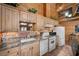 Close-up of kitchen with wood cabinets, stone backsplash, and white appliances at 4830 Silver Tip Way, Mount Charleston, NV 89124