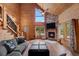 Cozy living room featuring wood walls, a stone fireplace, and a staircase with unique railing at 4830 Silver Tip Way, Mount Charleston, NV 89124