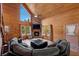 Cozy living room features wood walls, a stone fireplace, high ceilings, and a window view at 4830 Silver Tip Way, Mount Charleston, NV 89124