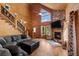 Inviting living room features wood paneled walls, stone fireplace, high ceilings, and a staircase at 4830 Silver Tip Way, Mount Charleston, NV 89124