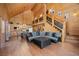 Bright living room with wood paneled walls, open floor plan, and decorative staircase at 4830 Silver Tip Way, Mount Charleston, NV 89124