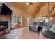 Spacious living room with wood paneled walls, stone fireplace, and plenty of natural light at 4830 Silver Tip Way, Mount Charleston, NV 89124
