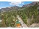 Picturesque mountain view featuring a cozy cabin surrounded by lush greenery and a winding road at 4830 Silver Tip Way, Mount Charleston, NV 89124