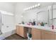 Bright bathroom features a double sink, a bathtub and a big mirror with a lot of lighting at 521 Landra Ln, Henderson, NV 89015